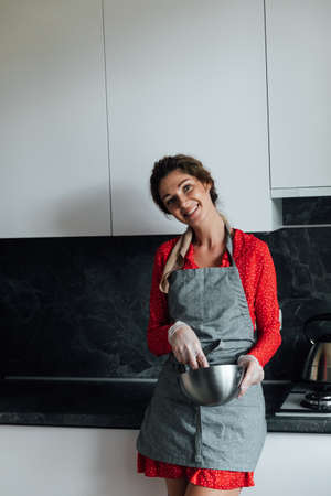 beautiful woman housewife cooks sweet delicious dessert in the kitchenの写真素材