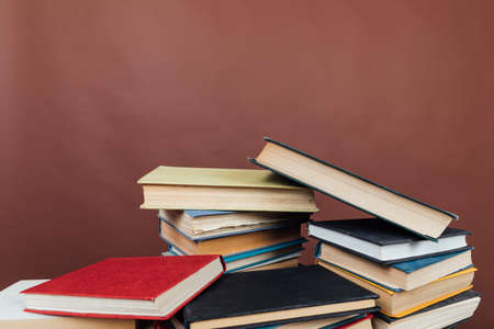 stacks of educational books in the library on a brown backgroundの写真素材