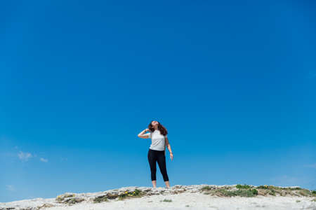 woman traveler standing on top of a mountain looking at the viewの写真素材