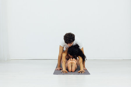 woman and man engaged in paired gymnastics yoga asanaの写真素材