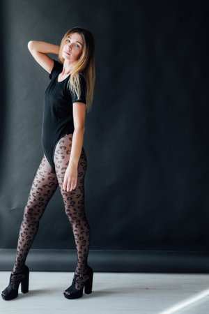 beautiful fashionable woman in black clothes and tightsの写真素材