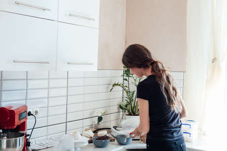 woman cooks delicious sweet desserts cakes in the kitchenの写真素材