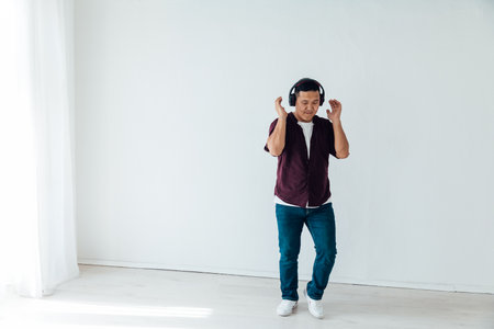 Asian man in headphones dancing to music aloneの写真素材