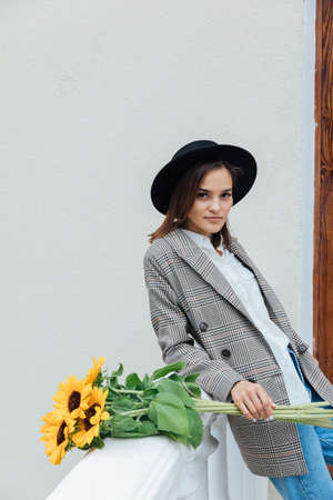 a beautiful woman walks around the city with sunflower flowersの写真素材