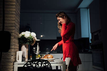 woman housewife prepares a romantic dinner with candles and wineの写真素材