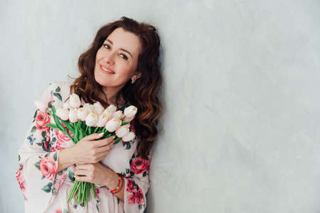 beautiful brunette woman 40 years old in a dress with flowersの写真素材