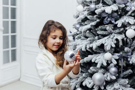 girl 5 years old decorates christmas tree new yearの写真素材