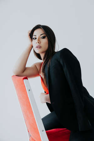 portrait beautiful fashionable oriental woman brunette on a white backgroundの写真素材