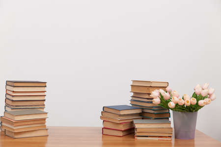 stacks of educational books for learning on a table with flowersの写真素材