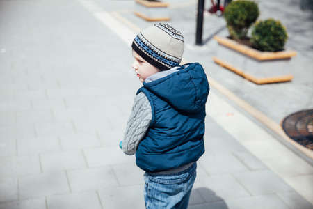 beautiful little boy riding a scooter on the streetの写真素材