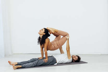 man and woman together doing exercises yoga asana fitnessの写真素材