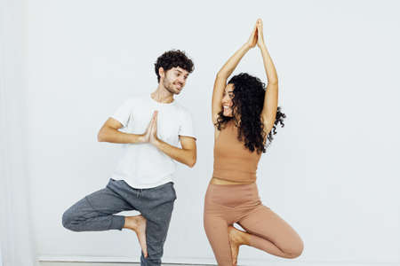 man and woman engaged in yoga asana gymnasticsの写真素材