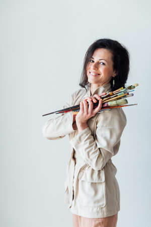 beautiful woman artist holds brushes in her hands for painting with paintsの写真素材