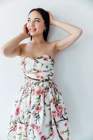 beautiful brunette woman in a summer dress with flowersの写真素材