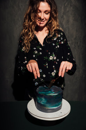 a woman cuts a sweet birthday cake for foodの写真素材