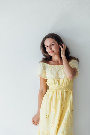 a woman in a yellow dress on a white background posesの写真素材