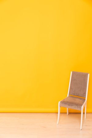 gray chair in the room against the yellow wall interior furnitureの写真素材