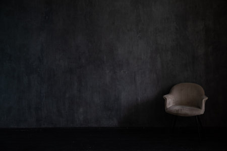 One grey vintage chair in the interior of an empty dark roomの写真素材