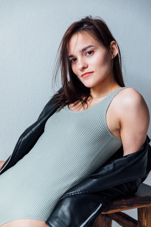 Brunette in gray bodysuit posing in studioの写真素材