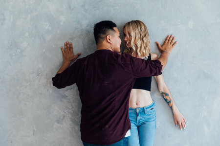 Man and woman in love posing on gray backgroundの写真素材