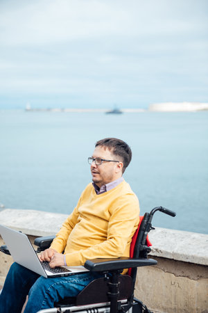 a special person with disabilities by the sea on a walkの写真素材