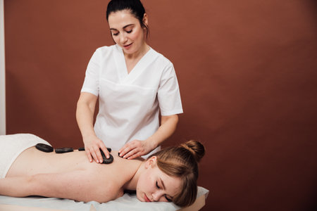 back massage with stones in the massage room relax spaの写真素材