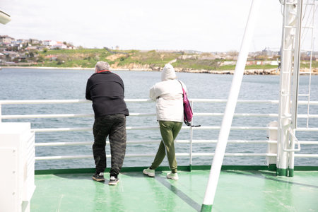 a couple of man and woman stand on a ferry boat trip by seaの写真素材