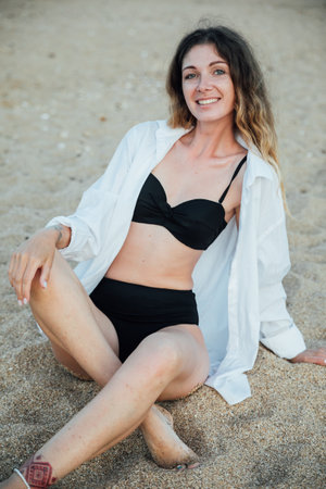 a woman in a black swimsuit at the sea on the beach rest walking tripの写真素材