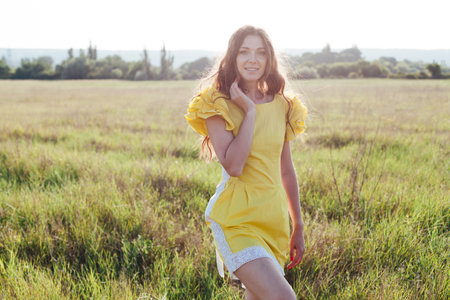 woman in yellow dress in nature holiday walk travel communicationの写真素材