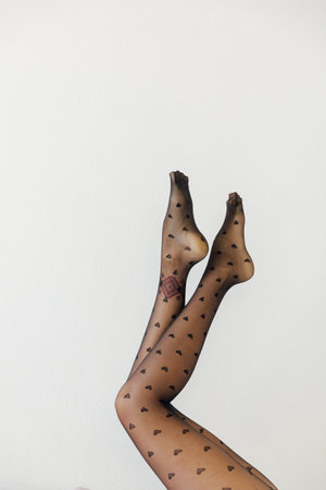 womens slender legs in black tights on a white backgroundの写真素材