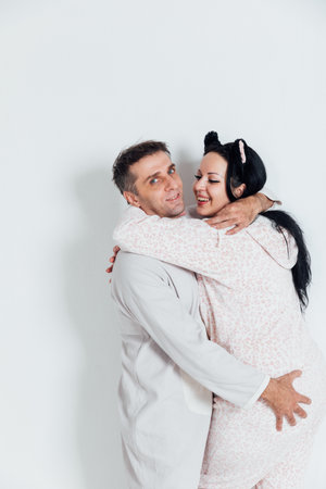 husband and wife man and woman in love in pajamas in the morning in a bright roomの写真素材