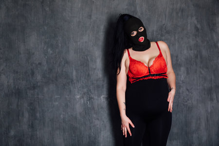 a woman with a closed face in a dark room on a black backgroundの写真素材