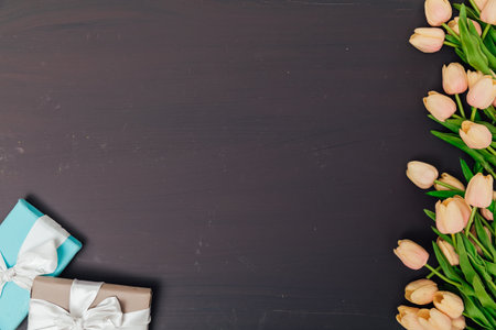 tulip flowers on a dark painted background with holiday giftsの写真素材