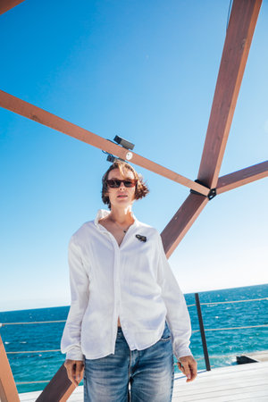 a woman in jeans stands near a wooden frameの写真素材