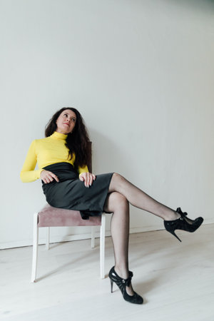 a beautiful woman rests on a pink chair in the officeの写真素材