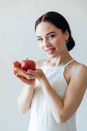 beautiful woman holding a red apple in her handsの写真素材