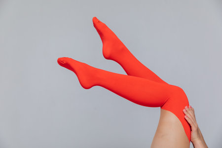 womens slender legs in red stockings on a wite backgroundの写真素材