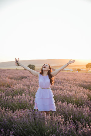 woman with bouquet in lavender nature walk journey at sunsetの写真素材
