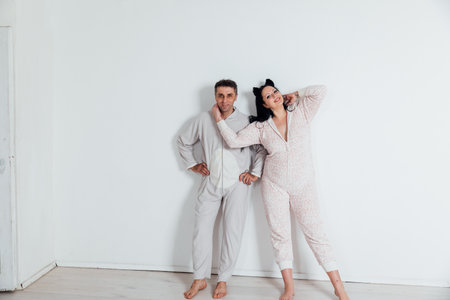 husband and wife in pajamas in love man and woman on a white backgroundの写真素材
