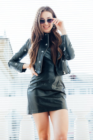 beautiful fashionable brunette woman posing on the balcony in the roomの写真素材