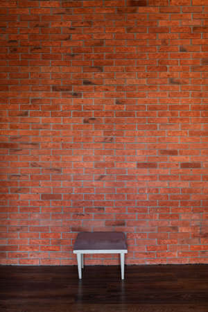 red brick wall in the room as a background with a stoolの写真素材