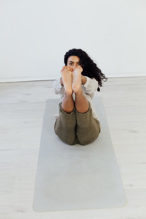 workout in the studio woman doing exercises yoga asana shavasana lotus poseの写真素材