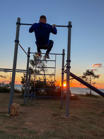 a man is engaged in sports on horizontal bars on the streetの写真素材