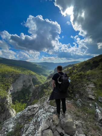 a man stands on a mountain and looks at nature hiking journeyの写真素材