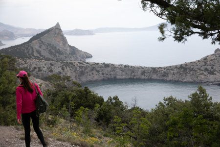 a woman on a hike walks on a mountain in nature journeyの写真素材