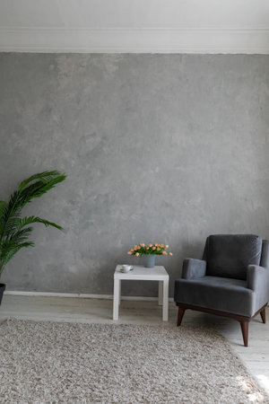 coffee table with flowers and with an armchair in the roomの写真素材