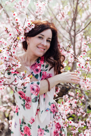 woman near pink flowering trees in peach garden nature springの写真素材