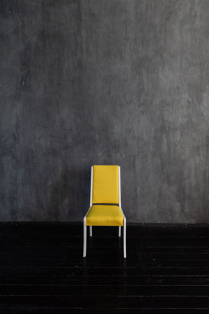 one yellow chair indoors on a dark background wall interiorの写真素材
