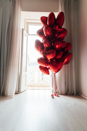 Lots of red balloons heart shaped balloons red color with toys in the roomの写真素材