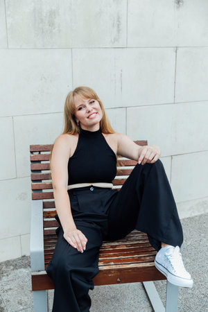 relaxed woman a free woman sitting on a wooden bench on the street